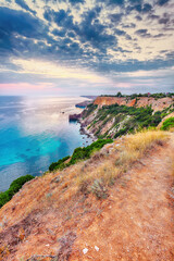Mesmerizing sunset at cape Fiolent with bushes grass and rocks at foreground