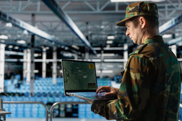 Data center army officer in uniform checking missile targeting software on laptop. Military...