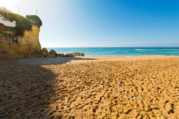 The sandy Praia de Carveiro Beach with the cliffs and hillside village of Carvoeiro, Portual in view along the Algarve coast of Southern Portugal.	