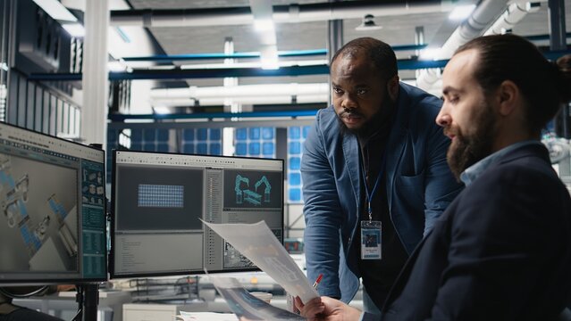 Factory supervisors diverse team sharing insight about production metrics, supporting industrial innovation and eco friendly clean energy development. Solar power improvement. Camera A.