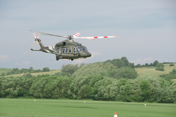 military transport helicopter flies at low altitude above the ground