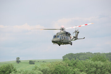 military transport helicopter flies at low altitude above the ground