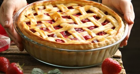 Woman putting tasty strawberry pie at wooden table, closeup - Powered by Adobe