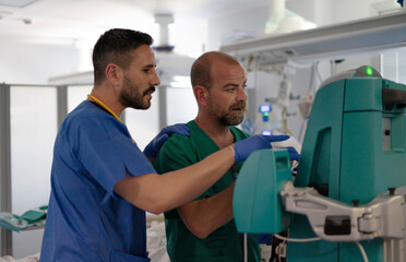 Two doctors discussing medical equipment settings in hospital room