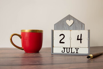 Female Hand holding wooden block calendar with the date July 24