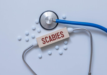 In the notebook is the text Scabies stethoscope, pills, and glasses