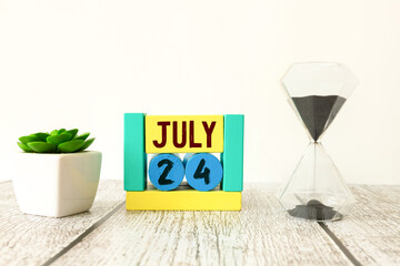 Female Hand holding wooden block calendar with the date July 24