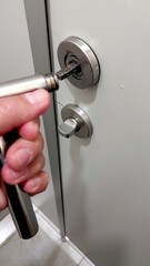 Handle Detached From the Door as a Person Attempts to Reattach It in a Residential Setting