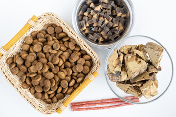 There are different kinds of pet treats in the bowl. Crispy breakfast cereals, chewing gums and...