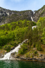 Naeroyfjord's lush mountains with a vibrant spring waterfall