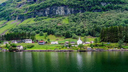 Small village with a white church by a tranquil fjord