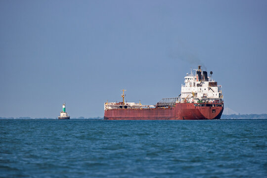Great Lakes freighter heading toward a lighthouse