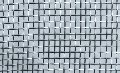 Detailed view of interconnected metallic wires forming a grid pattern in a geometric arrangement, showcasing industrial design and structural symmetry. Close-up macro shot