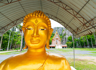 The large golden Buddha statue is enshrined in the outdoors of temple. Is placed of religious and...