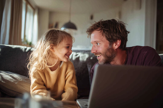 Happy father and daughter interact while using a laptop