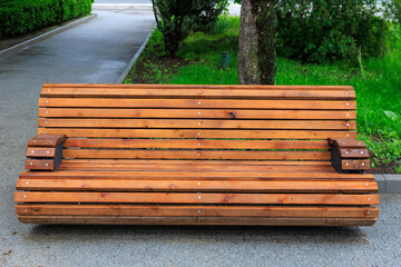Wooden bench in peaceful park setting surrounded by lush greenery