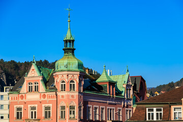 Historic pink castle-like building with green roof against clear blue sky