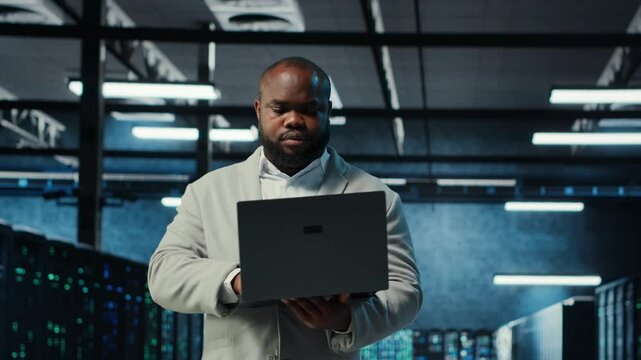 Data center engineer analyzing equipment performance, resolving technical issues. Server farm employee doing job tasks, overseeing operations, implementing efficiency optimizations, camera B