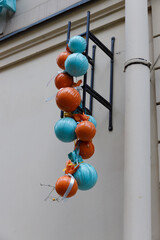 Colorful Decorative Balls Hanging on a Wall in Vibrant Blue and Orange, Showcasing a Unique Artistic Arrangement, Perfect for Adding Charm to Urban Spaces and Celebrations