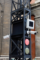 Traffic Signal Pole with Surveillance Cameras and Lights in an Urban Setting, Emphasizing Road...