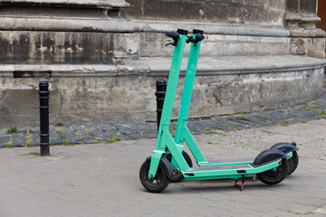 A Vibrant Green Electric Scooter Parked on a City Street, Showcasing Modern Urban Mobility...