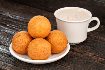 Fried cheese buñuelos accompanied by a hot chocolate drink - Typical Colombian cuisine