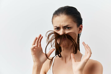 Hair, playful expression, woman with hair styled as mustache, light background, humorous portrait,...