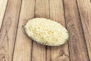 elongated grains of freshly cooked white rice on a wooden table