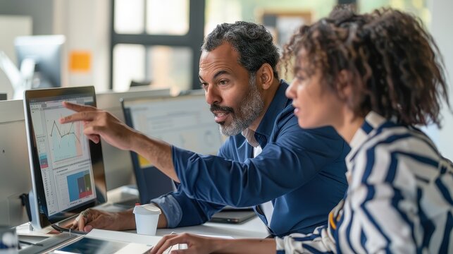 A man and woman looking at a computer screen