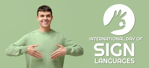 Young deaf mute man on green background. Banner for International Day of Sign Languages