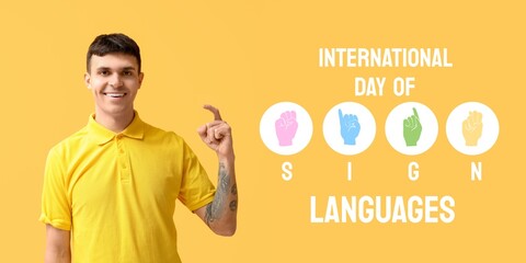 Young deaf mute man on yellow background. Banner for International Day of Sign Languages