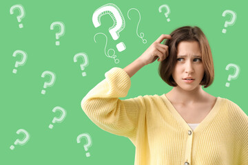 Wondering young woman on green background