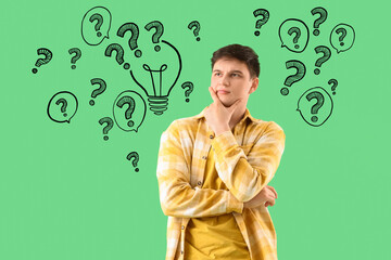 Wondering young man on green background
