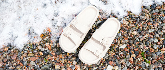 Beige flip-flops on sea shore
