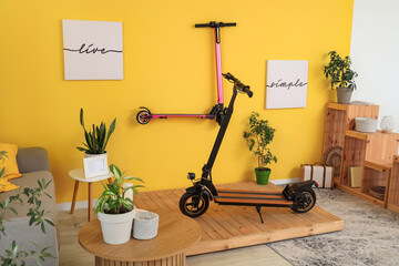 Interior of stylish living room with electric scooters, posters and plants