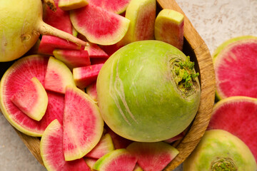 Wooden tray with ripe watermelon radishes on grey background