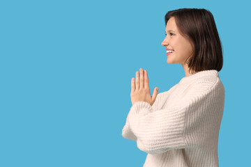 Pretty young woman meditating on blue background