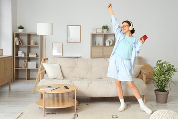 Young girl listening to music and dancing at home