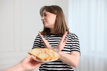 Gluten free diet. Woman refusing from bread indoors