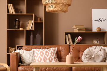 Flower in vase on coffee table near sofa in living room