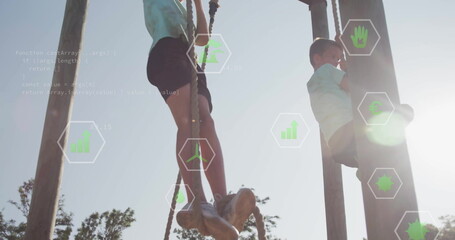 Climbing school-aged boys ascending wooden poles using thick ropes at park, with green data icons