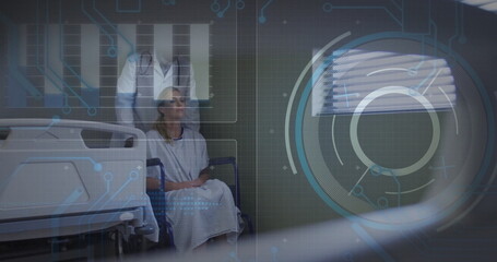 Sitting woman patient wearing gown in ward, with wheelchair, rails, stethoscope and digital overlay
