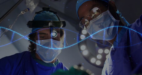 Two surgeons operating in operating room, with headlamp, masks, blue gowns and DNA helix graphic