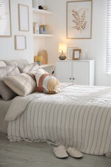 Comfortable bed with soft linens in room. Home textile