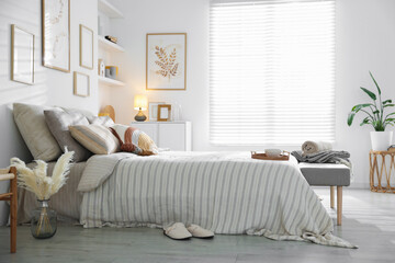 Comfortable bed with soft linens in room. Home textile