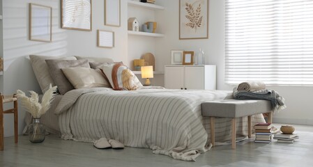 Comfortable bed with soft linens in room. Home textile