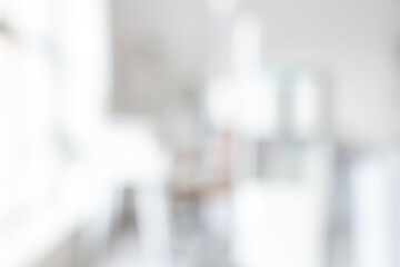 Blurred view of light office with water cooler and desks