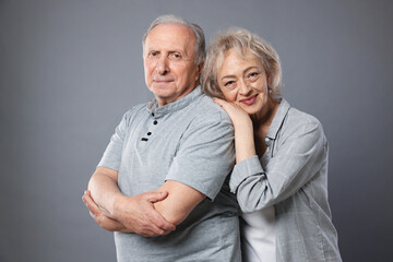Portrait of lovely senior couple on grey background