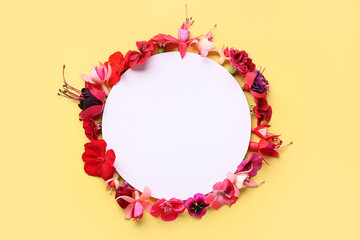Blank card with different beautiful edible flowers on yellow background