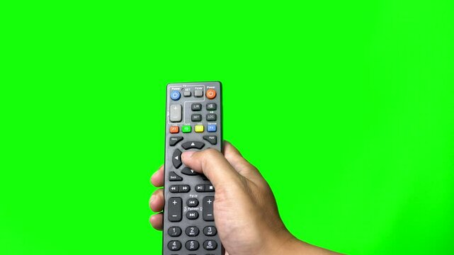 Hand holds TV remote and press the button, green screen background